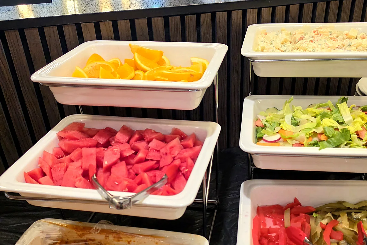 Buffet trays of fruit, salad and side dishes set out at Lakshmi Chowk