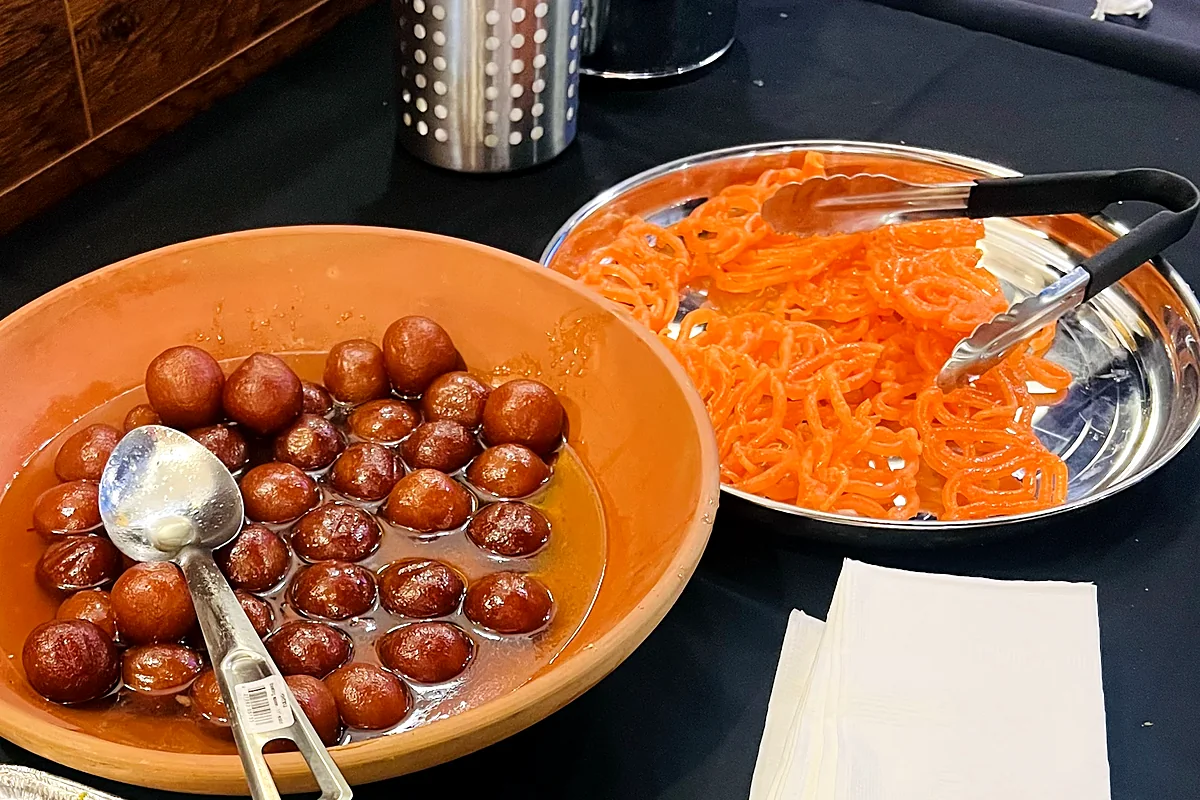 Gulab jamun in syrup and gajar halwa (carrot halwa) on the dessert table