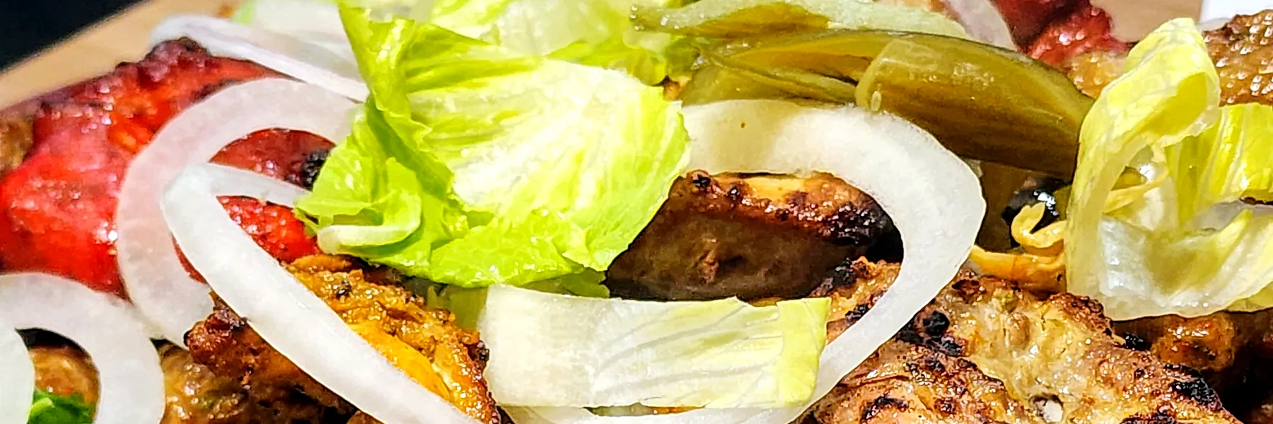 Close-up of a mixed BBQ platter with chicken tikka, malai tikka and kababs
